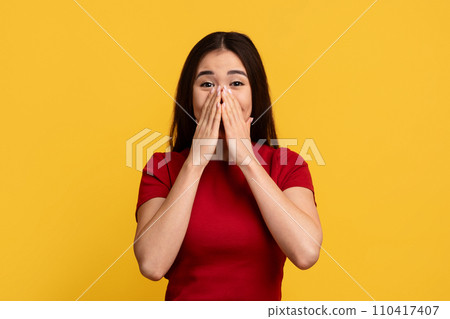 Surprised young chinese woman cover her mouth Surprised young chinese woman cover her mouth 110417407