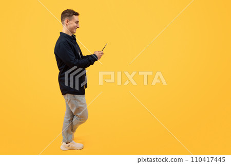 Stylish young guy in casual clothing using cell phone 110417445