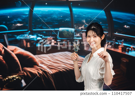 Woman enjoying sparkling wine at a space hotel Woman enjoying sparkling wine at a space hotel 110417507