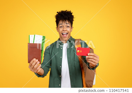 Happy black guy tourist showing credit card and passport 110417541