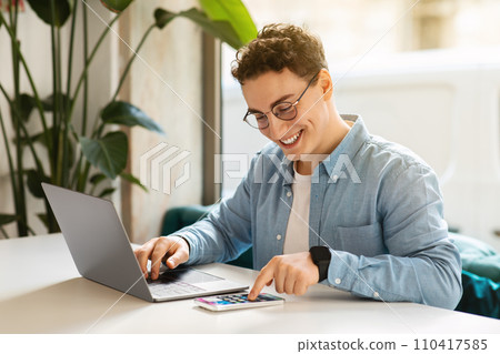 Happy young european guy student in glasses, typing on smartphone 110417585