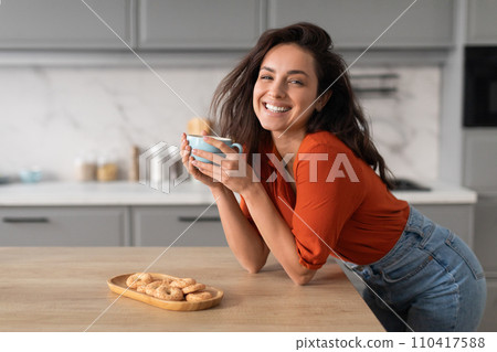 Joyful young woman enjoying coffee break at home Joyful young woman enjoying coffee break at home 110417588