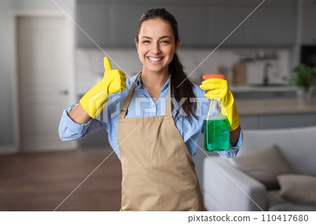 Happy housekeeper gives thumbs up with cleaning products Happy housekeeper gives thumbs up with cleaning products 110417680