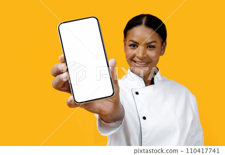 Happy African American Female Chef Showing Blank Smartphone At Camera Happy African American Female Chef Showing Blank Smartphone At Camera 110417741