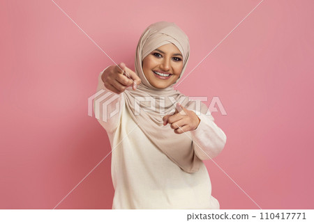 Arab woman in a hijab pointing with both hands at the camera 110417771