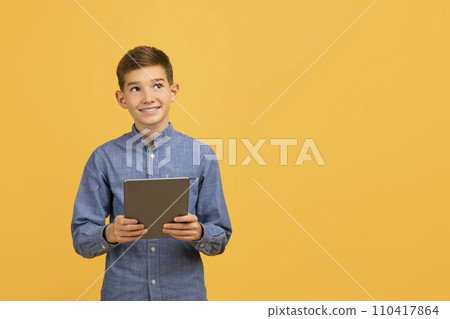 Young Smiling Teen Boy Holding Digital Tablet And Looking At Copy Space 110417864