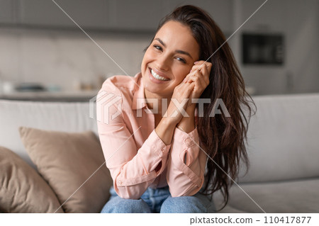 Smiling young woman casually posing with hands on face 110417877