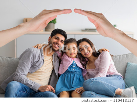 Happy interracial family posing at home under hands roof Happy interracial family posing at home under hands roof 110418137