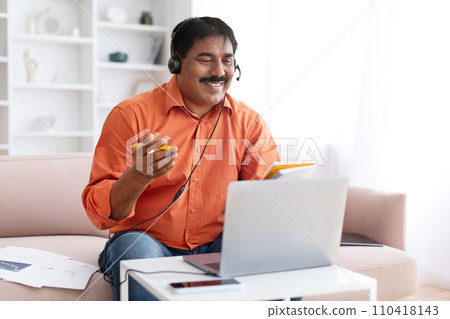 Mature indian man studying online from home Mature indian man studying online from home 110418143