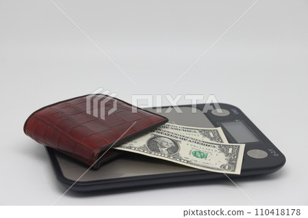 Brown wallet with banknotes on electronic kitchen scales. Symbol of accounting and family finance planning. 110418178