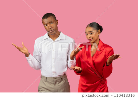 Confused black couple shrugging, wearing elegant attire, pink background Confused black couple shrugging, wearing elegant attire, pink background 110418316