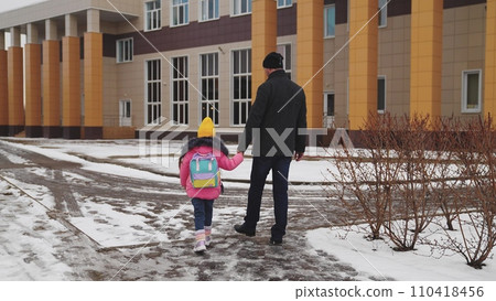 caring parent takes little girl school, little child goes school, child holds his father hand, view from back, school snowy road, child jacket boots walks cold snow school, daughter dad happy family, caring parent takes little girl school, little child goes school, child holds his father hand, view from back, school snowy road, child jacket boots walks cold snow school, daughter dad happy family, 110418456