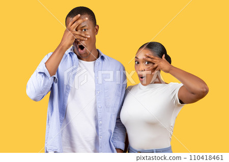 Shocked black couple with hands over eyes, humorous, yellow background Shocked black couple with hands over eyes, humorous, yellow background 110418461