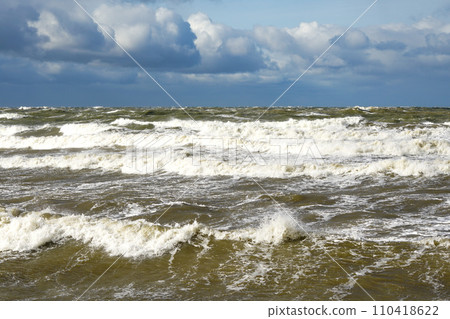 Stormy weather seascape, big waves with foam, low dark cumulus clouds, stormy sea view Stormy weather seascape, big waves with foam, low dark cumulus clouds, stormy sea view 110418622