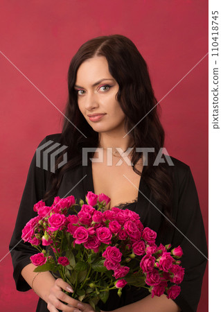 Beautiful woman with a bouquet of small pink roses Beautiful woman with a bouquet of small pink roses 110418745