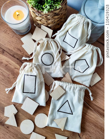 Eco reusable cotton bags for games, geometric wooden shapes on wooden background 110419328