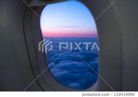 Amazing view of clouds and sunset in window on an airplane. Amazing view of clouds and sunset in window on an airplane. 110419990