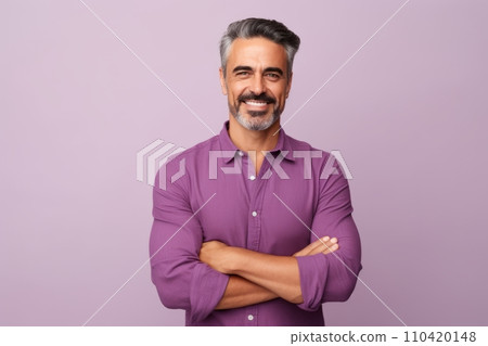 Portrait of handsome mature man with crossed arms looking at camera and smiling, standing against purple background. Portrait of handsome mature man with crossed arms looking at camera and smiling, standing against purple background. 110420148