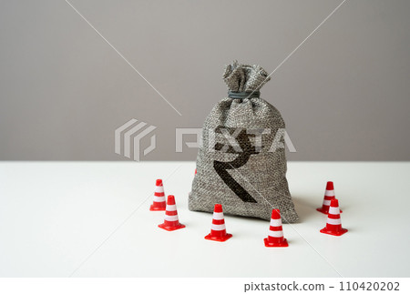 Indian rupee money bag blocked by road cones. Freezing of accounts and sanctions on capital. Suspicious funds with unknown sources. National money reserve. 110420202
