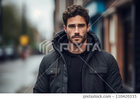 Portrait of a handsome young man in a black jacket on the street. 110420335