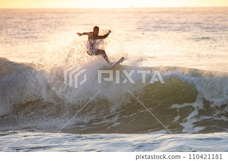 Surfer in action at sunset Surfer in action at sunset 110421181
