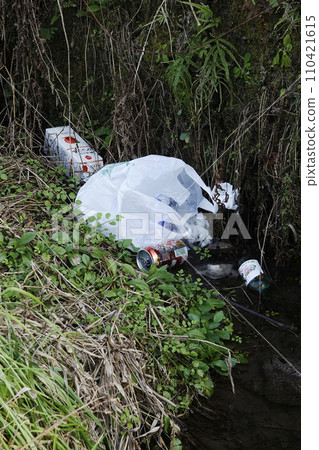 Plastic bags, paper cartons, empty cans, and empty bottles thrown into the river by heartless people 110421615