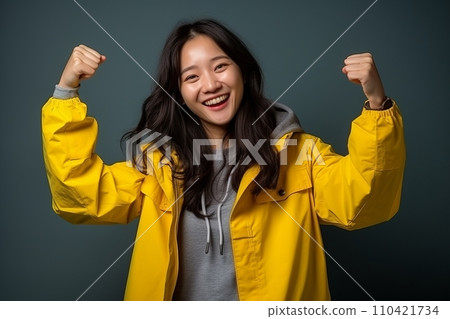 AI-generated content. Portrait of a happy young asian woman in yellow raincoat. 110421734
