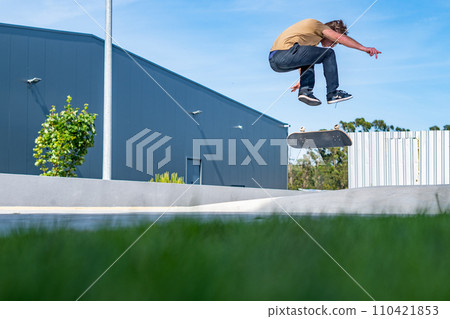 Skateboarder doing a flip trick Skateboarder doing a flip trick 110421853