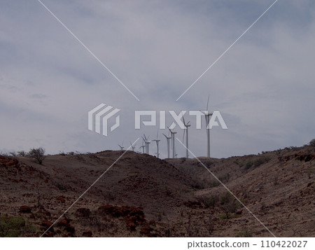 Modern Windmills spin on hillside on Maui 110422027