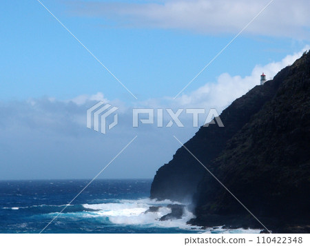 Makapu'u Lighthouse on cliffside as wave crashing into rocks below 110422348