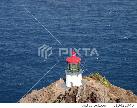 Makapu'u Lighthouse on cliffside mountain top with ocean below 110422349