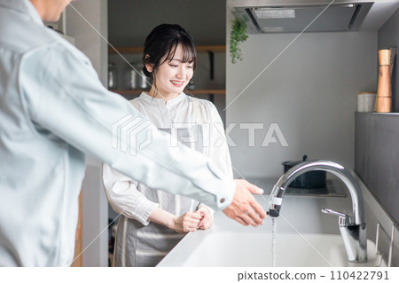 A housewife woman receives explanations from a plumber/equipment shop in the kitchen A housewife woman receives explanations from a plumber/equipment shop in the kitchen 110422791