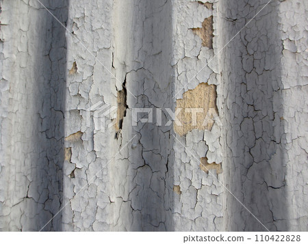 Crack gray paint on grooved wall 110422828
