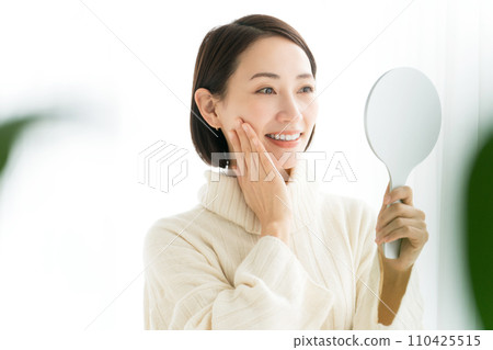 A smiling woman with a hand mirror 110425515