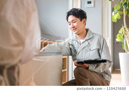 一位家庭主婦正在聽建築公司、設備商店和穿著工作服的水管工的男人說話（諮詢、合約、會議） 110425680