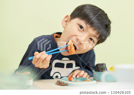 A young boy eating lunch with a smile 110426105