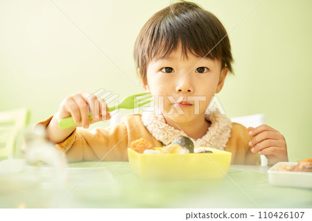 A young boy eating his bento deliciously A young boy eating his bento deliciously 110426107