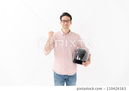 A man holding a helmet and doing a fist pump 110426163