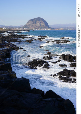 Sanbangsan Mountain seen over the waves breaking on the rock 110426388