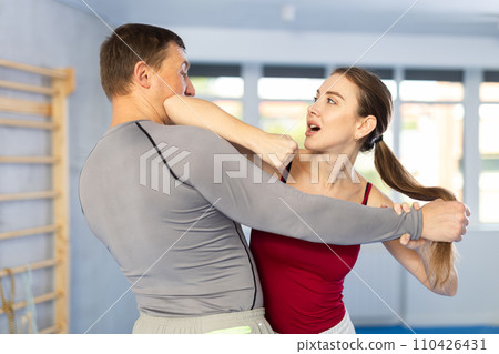 Adult man and young woman training self-defense techniques 110426431