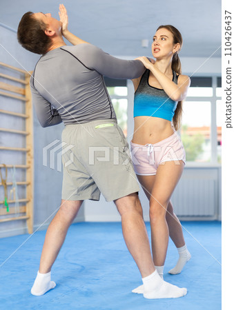 Woman hits man attacker on head during self defense training session Woman hits man attacker on head during self defense training session 110426437
