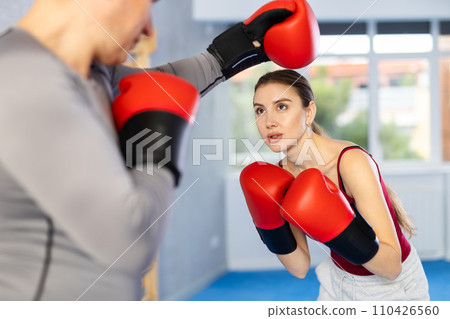 Adult man and young woman train boxing 110426560
