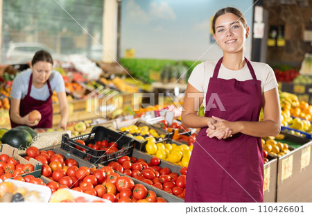 Positive and friendly store girl employee stands with arms crossed on chest and waits for customers Positive and friendly store girl employee stands with arms crossed on chest and waits for customers 110426601