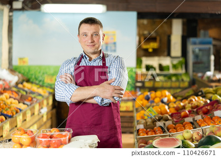 Positive and friendly store man employee stands with arms crossed on chest and waits for customers Positive and friendly store man employee stands with arms crossed on chest and waits for customers 110426671