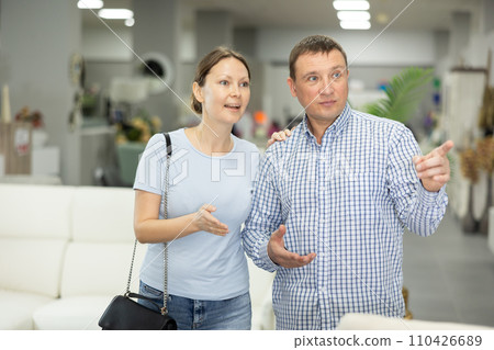 Spouses buyer looks around in showroom and chooses right fit furniture 110426689