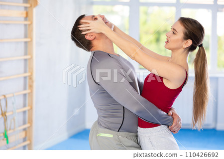 Adult man and young woman training self-defense techniques Adult man and young woman training self-defense techniques 110426692