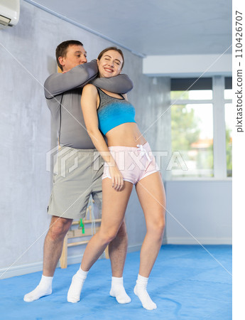 Adult man and young woman training self-defense techniques 110426707