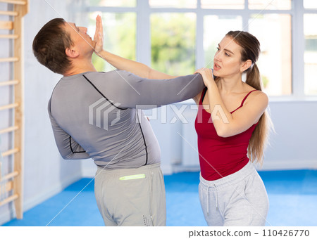 Adult man and young woman training self-defense techniques Adult man and young woman training self-defense techniques 110426770