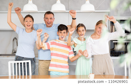Big friendly family is rejoicing with happiness and raising their hands up they shout with happiness 110426901