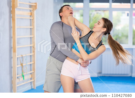 Young girl practicing self-defense techniques in pair with middle-aged man 110427080